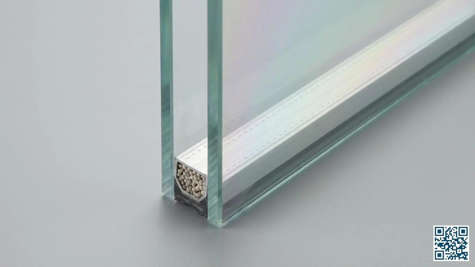 Close-up van een isolerende glasunit met zichtbare spacer bar en coating reflectie op het glasoppervlak